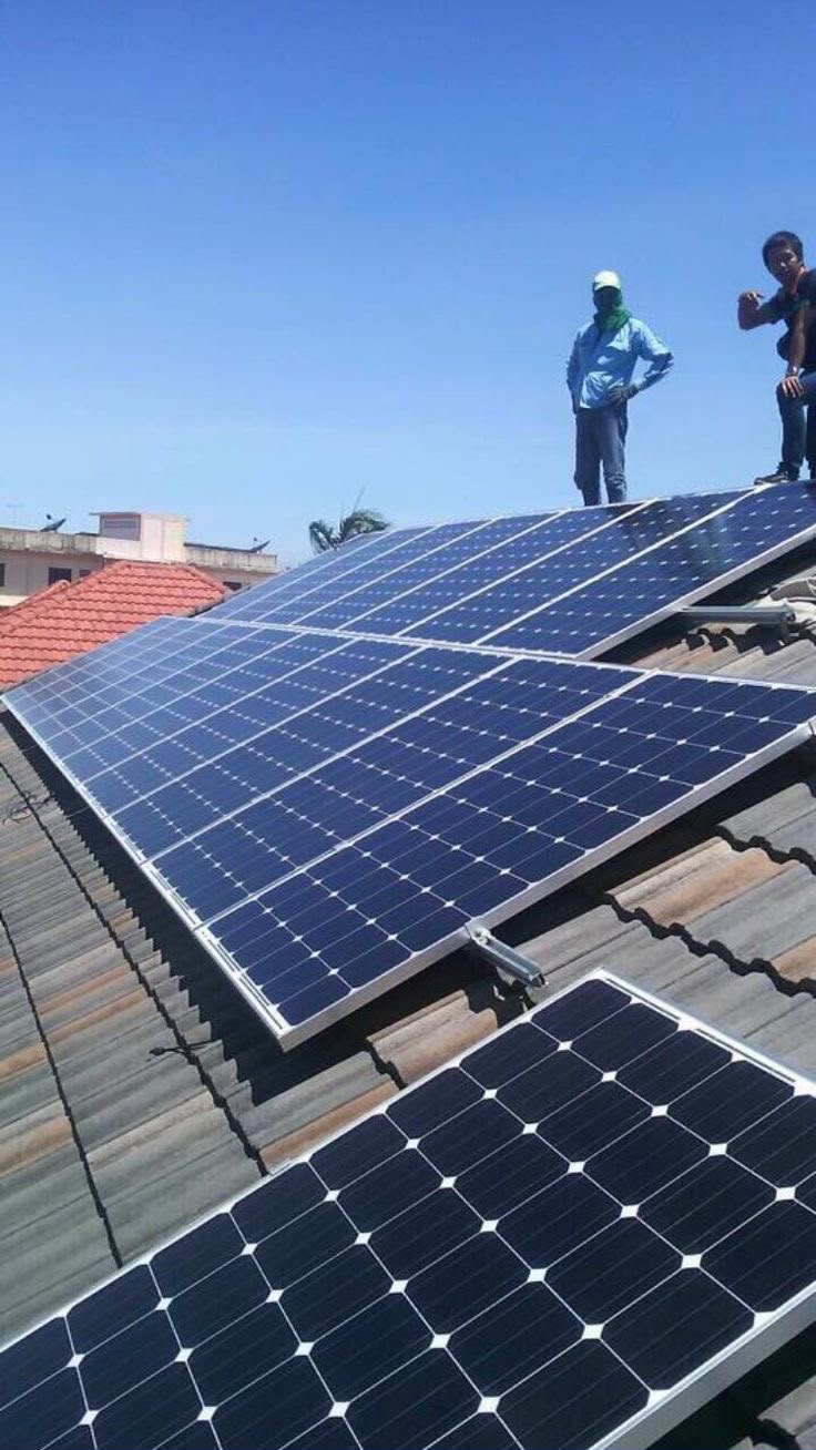Técnicos a instalar painéis solares num telhado